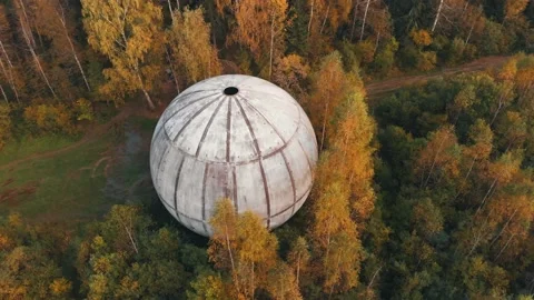 Large white sphere with hole on top located in dense forest Stock Footage 153937606