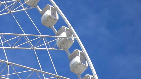 Large white spinning ferris wheel against at clean blue sky background. Stock Footage 257109746