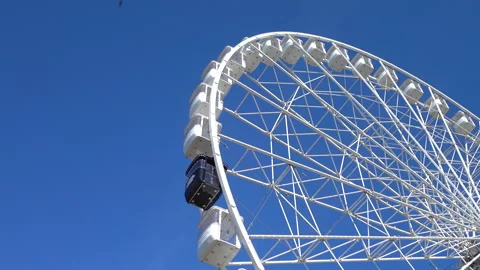 Large white spinning ferris wheel against at clean blue sky background 4K. 스톡 동영상 257111176