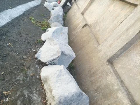 Large white stone on the roadside Stock Photos