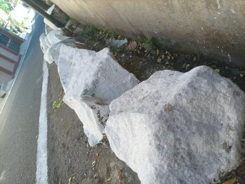 Large white stone on the roadside Stock Photos