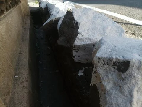 Large white stone on the roadside Stock Photos