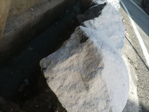 Large white stone on the roadside Stock-Fotos