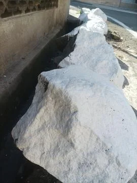 Large white stone on the roadside Stock Photos