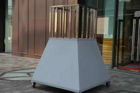 A large white triangular metal box on wheels with three long vertical coppe.. Stock Photos