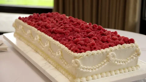 A large white vanilla wedding cake in a rectangular shape, decorated with fresh Stock Footage 323636512