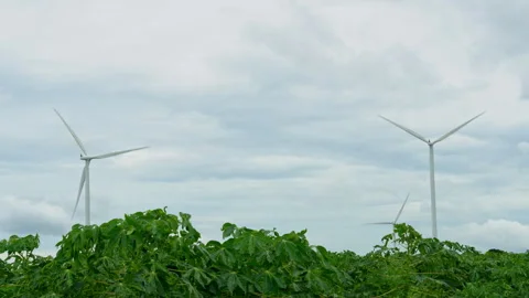 Large white wind turbines generating clean energy in rural field under cloudy sk Video stock 342906411