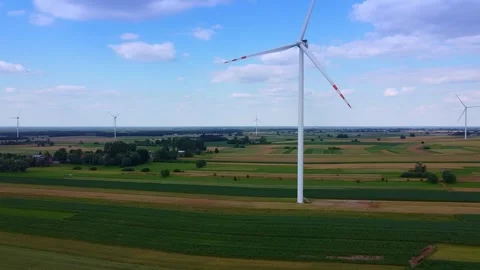 Large white wind turbines spinning over rural farmland plains Video stock 342591102