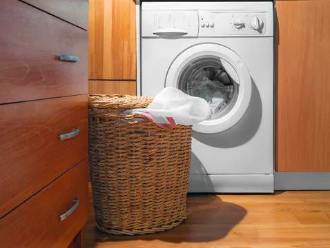 Large Wicker Laundry Basket, Open Lid Near the Washing Machine with Laundry. Foto stock