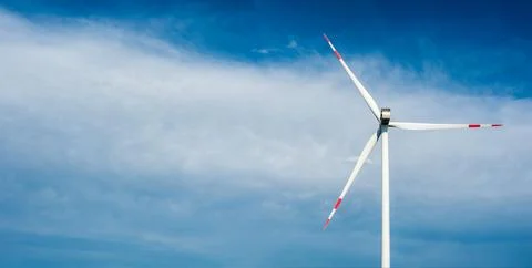 Large wind generator close-up against the background of the sky and clouds. C Stock Photos