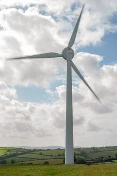 Large Wind Turbine Generating Renewable Energy on Rolling Green Hills Stock Photos