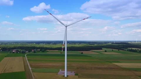 Large wind turbine operating in rural farmland under blue sky Video stock 342591009