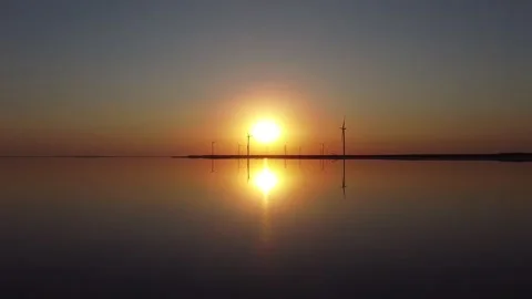 Large wind turbine rotating blades of in field against background of orange Stock Footage 151685271