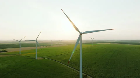 Large wind turbines with blades in field aerial view bright sunrise Stock Footage 232371925