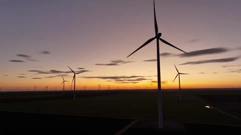 Large wind turbines with blades in field aerial view bright orange sunset Stock Footage 266502677