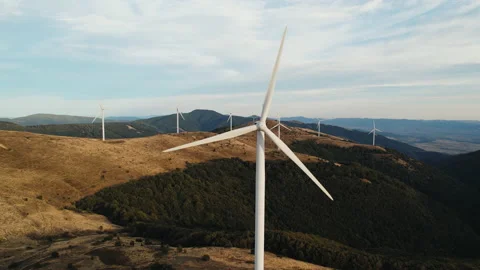 Large wind turbines with blades in mountains on peaks aerial view Stock Footage 208943879