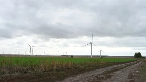 Large wind turbines with blades in the wind park on the background cloudy sky. Video stock 165890235