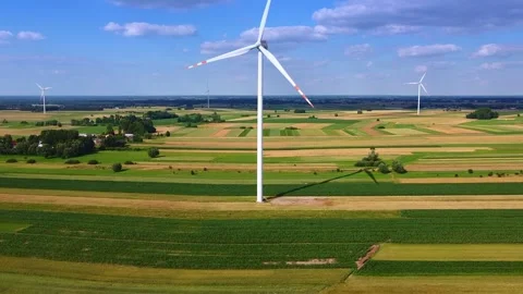 Large wind turbines generating power over rural farmland plains Video stock 342591467