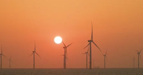 Large wind turbines producing plant on the sea under sunset Stock Footage 239572553