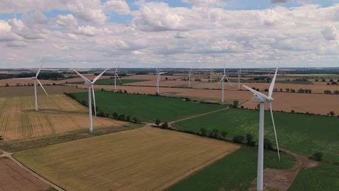 Large Wind Turbines Rotate Slowly in a Wide Rural Field During a Sunny Summer Video stock 341838153