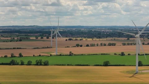 Large Wind Turbines Rotating Over Rural Agricultural Fields During a Bright Stock Footage 341838238