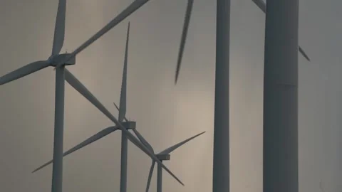 Large windmill silhouettes with blades rotating in grey sky Video stock 157321115