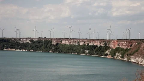 Large windmill turbines on a seaside cliff providing energy, panoramic view Stock Footage 70573102