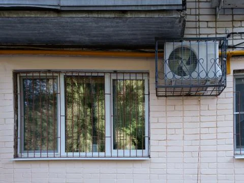 A large window and air conditioning on the wall of the building. Stock Photos