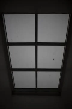 Large window in the ceiling. Faint light through glass. Grey day outside th.. Stock Photos