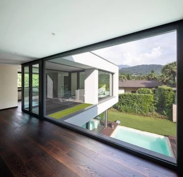 Large window in hallway of modern villa overlooking the private pool Stock Photos