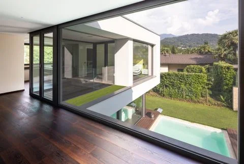 Large window in hallway of modern villa overlooking the private pool Stock Photos