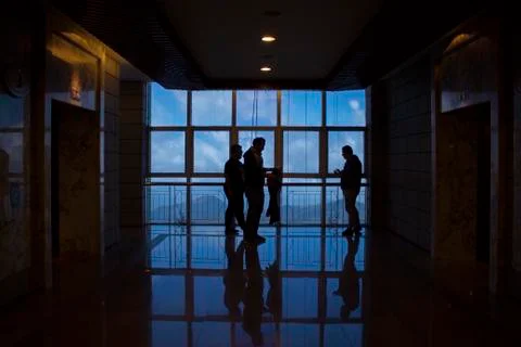 Large window with reflection during the morning and people in frame. Stock Photos