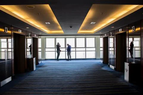 Large window with reflection during the morning and people in frame. Stock Photos