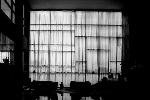 Large window with sheer curtains in a dimly lit room Stock Photos
