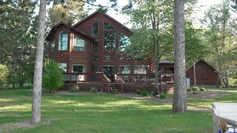Large wooden cabin surrounded by trees in summer Stock Footage 344905834