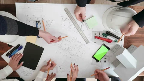 Large work table on which are glasses, phone, markers, pencils, rulers. Hands of Stock Footage 103032103