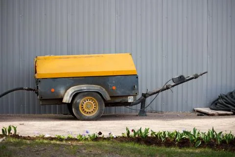 A large working air compressor stands near the fence next to the Gatchina Pal Stock Photos