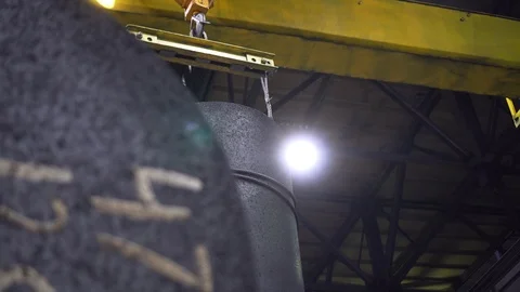 Large workshop crane moves heavy graphite rod fixed by steel cable Stock Footage 115927838