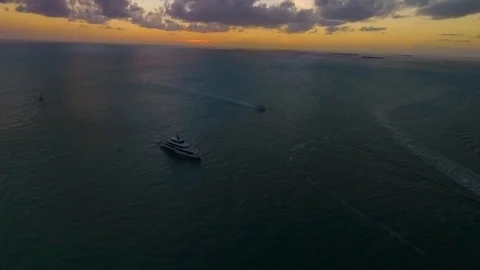A large yacht sails as the sun sets: all captured via a drone in sharp 4K Video stock 106067141