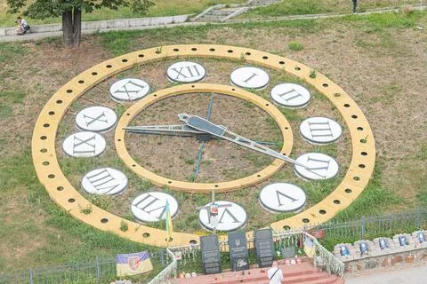 A large yellow-bordered clock with Roman numerals, almost at eleven oclock,.. 库存照片