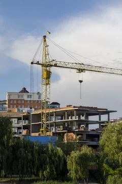 Large yellow crane next to a modern high-rise building under construction a.. Foto stock