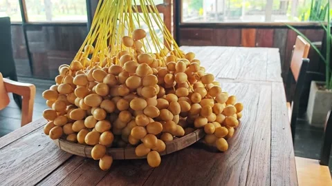 Large Yellow Date Palm Bunch on Wooden Table by Window. Stock Footage 340487931