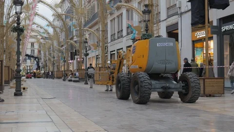 Large yellow device with articulated arm and a cabin in a pedestrian street Stock Footage 120599722