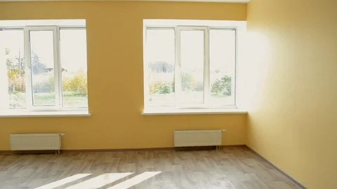 Large yellow empty room with three large windows after repair and restoration Stock Footage 106410609
