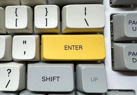 Large yellow Enter button in English on mechanical white keyboard for Stock Photos