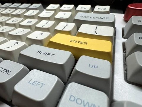 Large yellow Enter button in English on mechanical white keyboard for Stock Photos