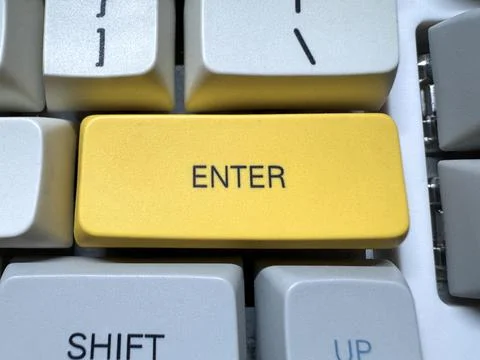 Large yellow Enter button on mechanical white keyboard for programmers with gray Stock Photos