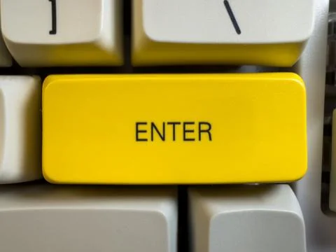 Large yellow Enter button on mechanical white keyboard for programmers with gray Stock Photos