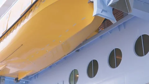 Large Yellow Lifeboat Mounted on Side Hull of Cruise Ship Stock Footage 346503947