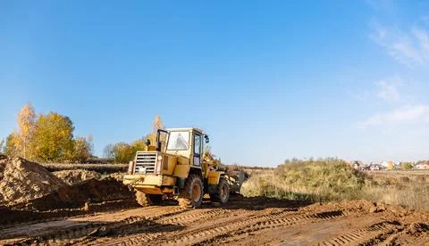 Large yellow wheel loader aligns a piece of land for a new building. Preparat Stock Photos